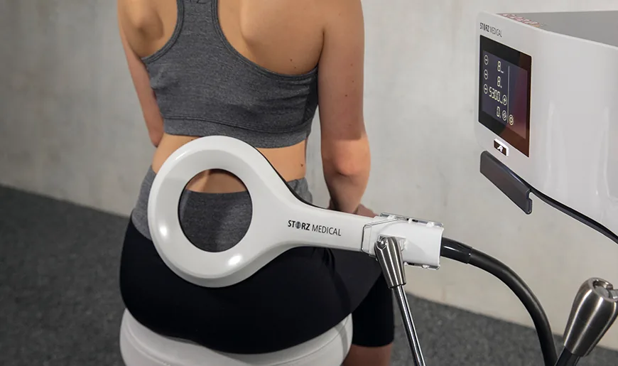 MAGNETOLITH EMTT applicator positioned near a seated patient lower back