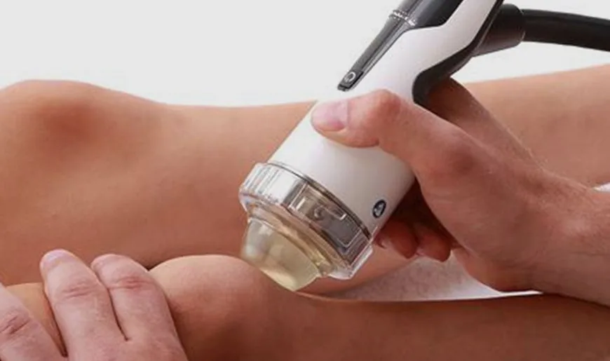 Focused shockwave therapy applicator positioned on a patient knee
